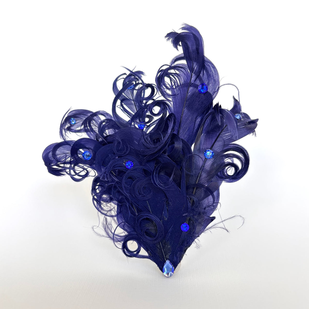 Handmade deep violet feather hair clip and brooch with layered curled feathers, sculptural loops and brilliant blue Swarovski crystal detailing by Nicole Ho.