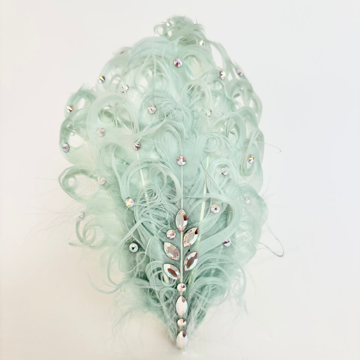 Handmade pale mint green feather hair clip and brooch with soft curled feathers, scattered Swarovski crystals and a leaf-like crystal centre detail by Nicole Ho.