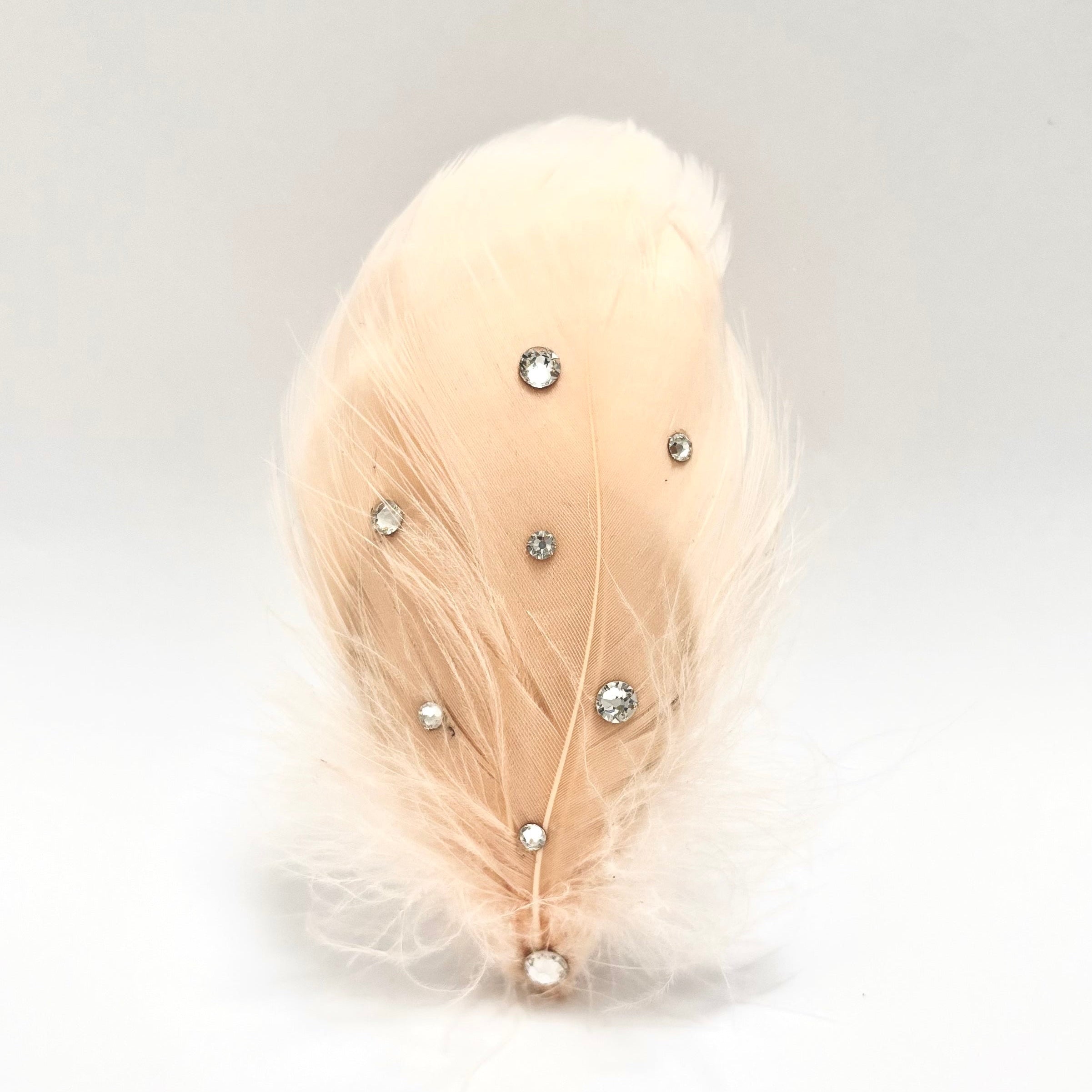 Handmade yellow and brown feather hair clip with bright fluffy texture, patterned feather detail, and subtle crystal radiance for expressive styling by Nicole Ho.