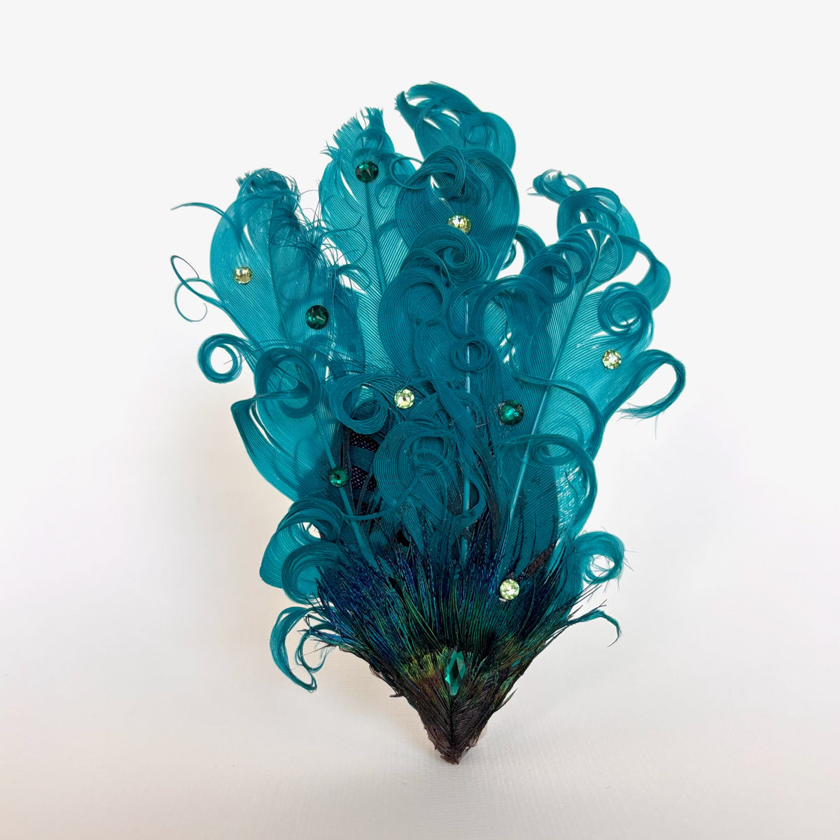 Handmade teal feather hair clip and brooch with flowing curled feathers, Swarovski crystal detailing and a natural peacock feather accent by Nicole Ho.