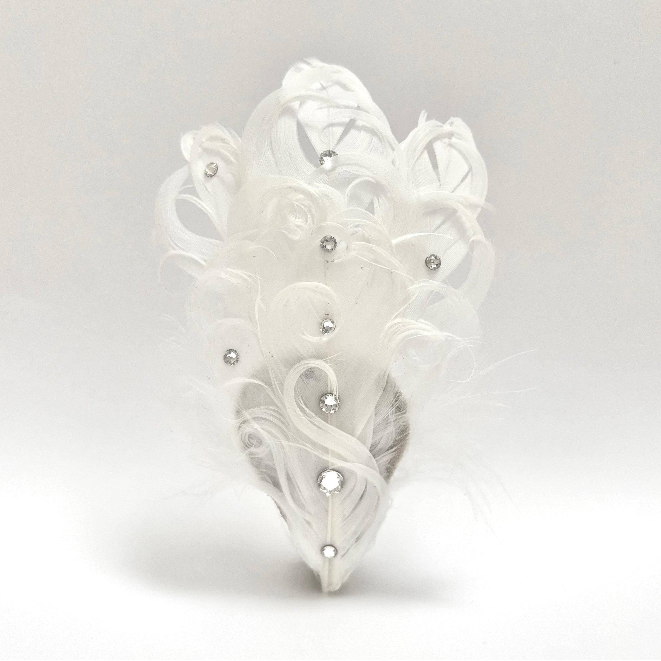 Handmade white feather hair clip with smooth curved outline, soft natural fluff, and delicate crystal detailing for luminous hairstyles by Nicole Ho.